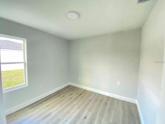 empty room with light hardwood / wood-style floors and a wealth of natural light