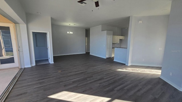 unfurnished living room featuring ceiling fan with notable chandelier and dark hardwood / wood-style flooring