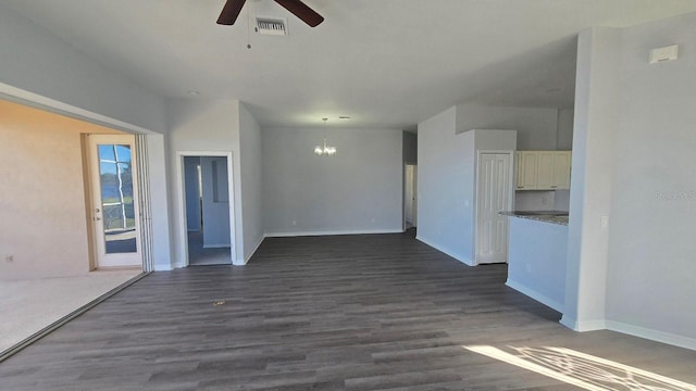 empty room with ceiling fan with notable chandelier and dark hardwood / wood-style floors