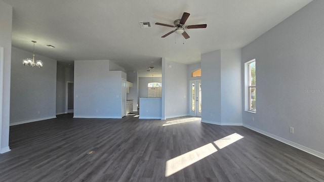 unfurnished living room featuring ceiling fan with notable chandelier and dark wood-type flooring