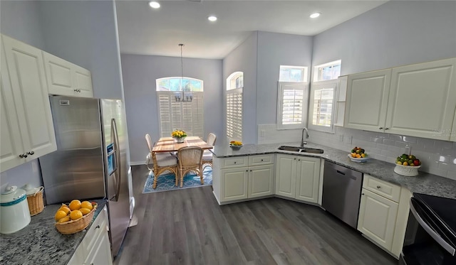 kitchen with sink, dark hardwood / wood-style flooring, pendant lighting, white cabinets, and appliances with stainless steel finishes