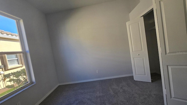 spare room with dark colored carpet