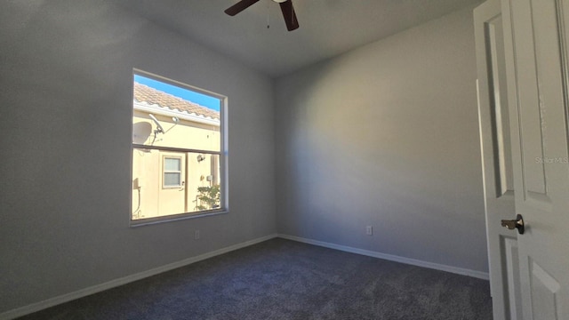 empty room featuring dark colored carpet and ceiling fan