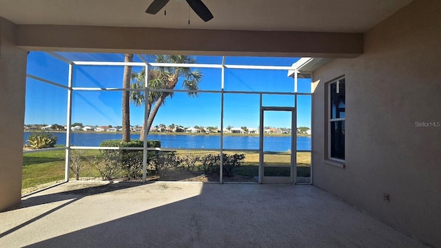 view of patio / terrace with a lanai, ceiling fan, and a water view