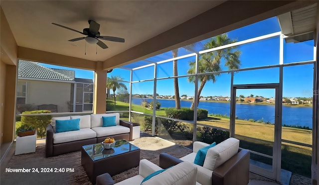 sunroom / solarium featuring ceiling fan and a water view