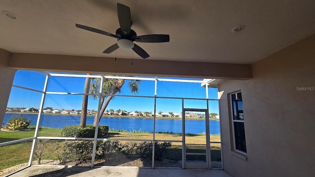 unfurnished sunroom featuring a water view and ceiling fan