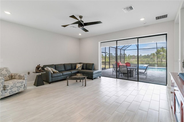 living room with light hardwood / wood-style floors and ceiling fan