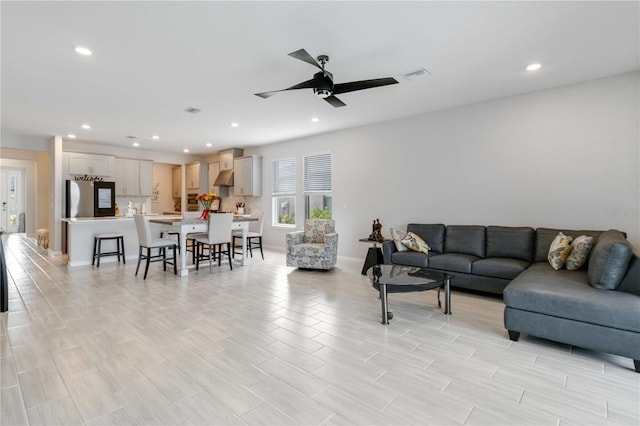 living room featuring light hardwood / wood-style flooring and ceiling fan