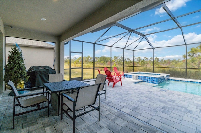 view of patio with a lanai, grilling area, and a pool with hot tub