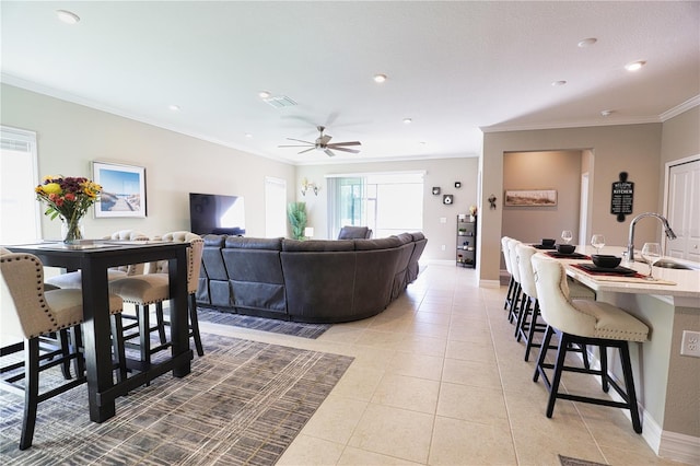 tiled living room with ceiling fan, sink, and ornamental molding