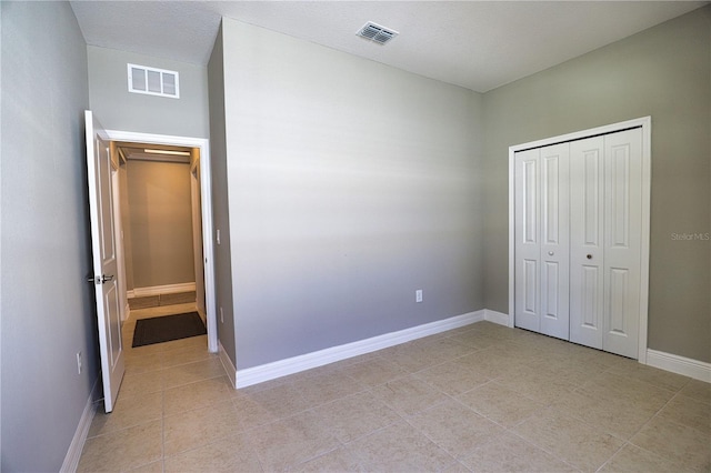 unfurnished bedroom with light tile patterned floors and a closet