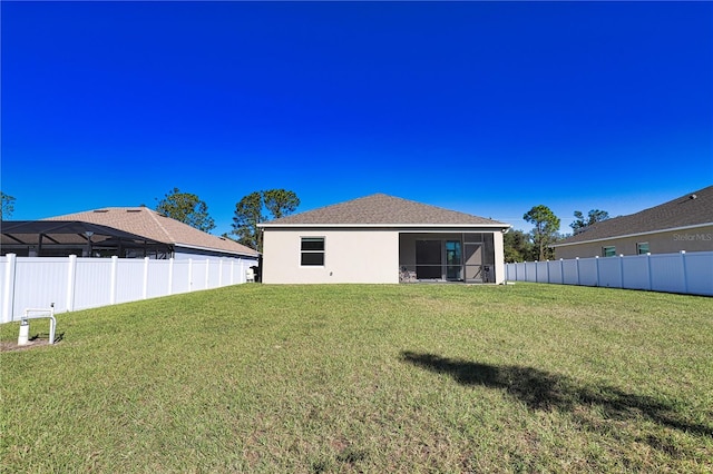 rear view of property featuring a sunroom and a yard