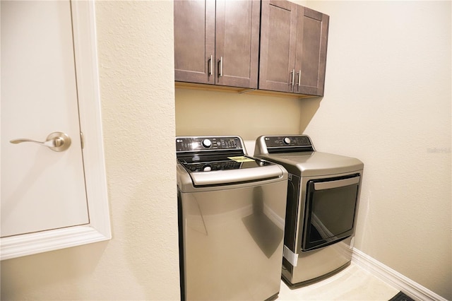 washroom featuring cabinets, separate washer and dryer, and tile patterned floors