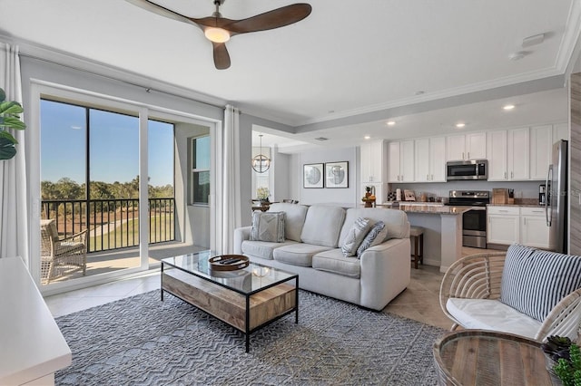 tiled living room with ceiling fan with notable chandelier and ornamental molding