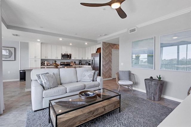 living room featuring ceiling fan and crown molding