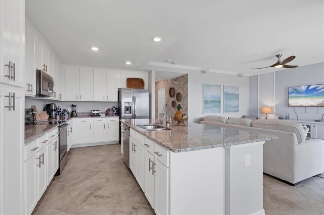 kitchen with sink, light stone counters, a center island with sink, white cabinets, and appliances with stainless steel finishes