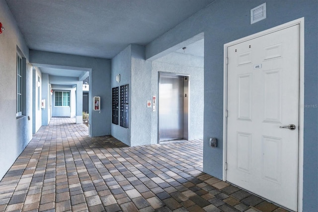 corridor with mail boxes and elevator