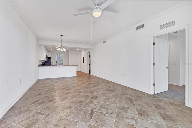 unfurnished living room featuring ceiling fan with notable chandelier and ornamental molding