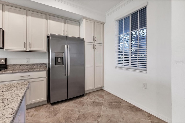 kitchen featuring light stone countertops, stainless steel fridge, and ornamental molding