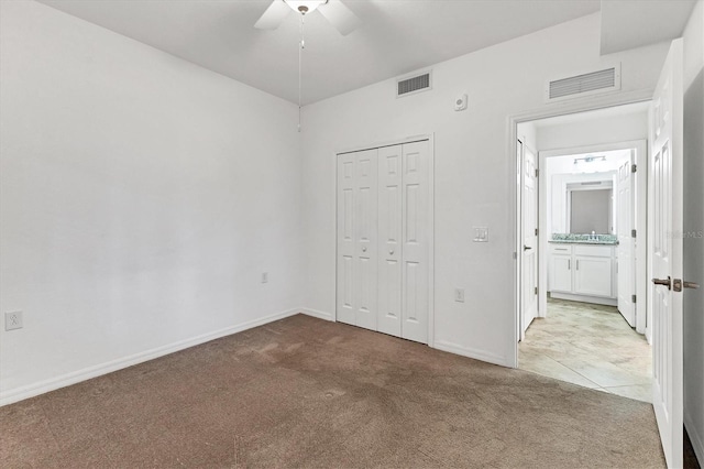 unfurnished bedroom with light carpet, a closet, and ceiling fan