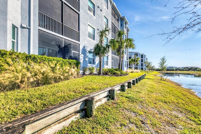 view of property's community with a yard and a water view