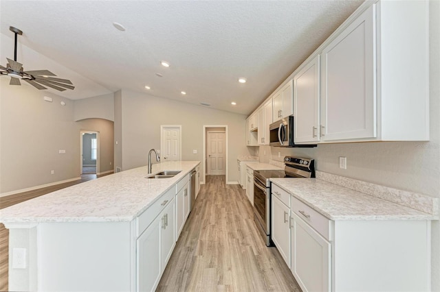 kitchen featuring a center island with sink, white cabinets, stainless steel appliances, and light hardwood / wood-style floors