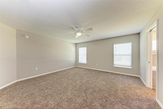 carpeted spare room featuring a textured ceiling and ceiling fan