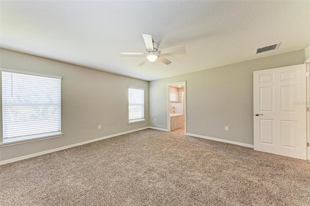 unfurnished room with ceiling fan, carpet, and a textured ceiling