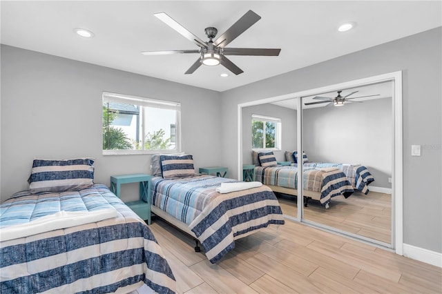 bedroom with ceiling fan, a closet, and light hardwood / wood-style flooring