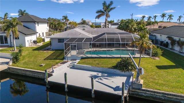 rear view of property with a lawn, a patio area, and a lanai