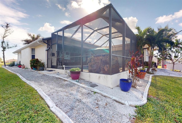 view of home's exterior with a lanai and a yard