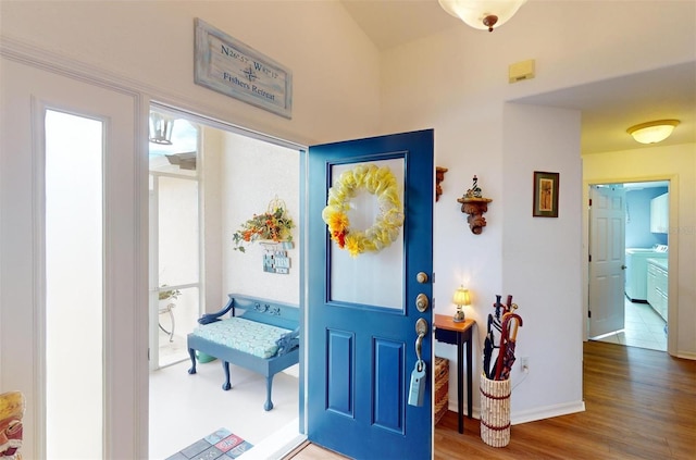 foyer entrance with washer / clothes dryer and hardwood / wood-style floors