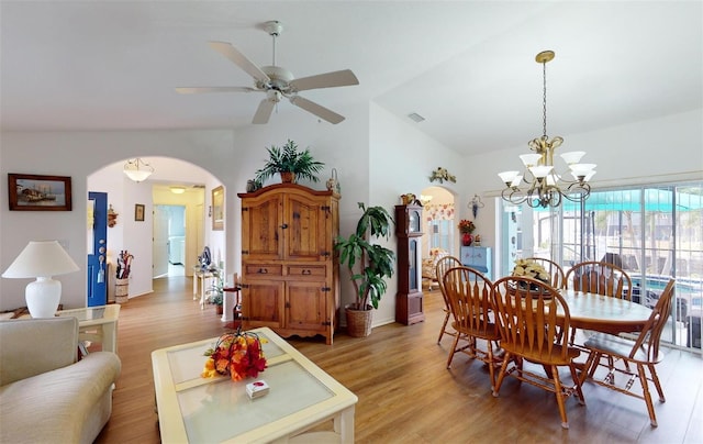 dining space featuring ceiling fan with notable chandelier, light hardwood / wood-style floors, and lofted ceiling