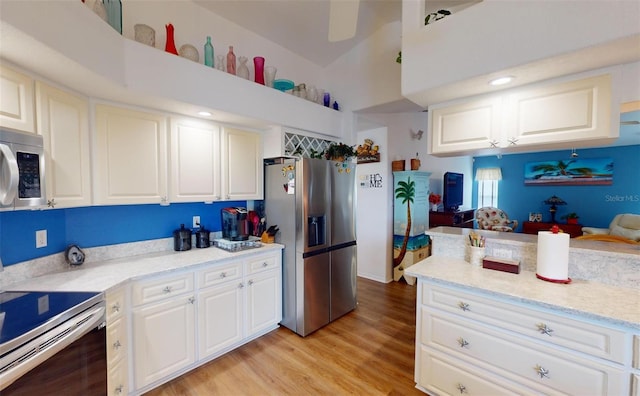 kitchen featuring light stone countertops, stainless steel appliances, light hardwood / wood-style flooring, white cabinets, and lofted ceiling