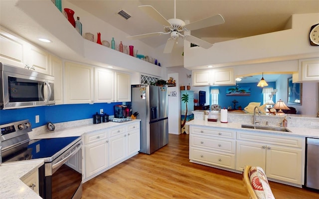 kitchen with sink, white cabinets, light hardwood / wood-style flooring, and appliances with stainless steel finishes