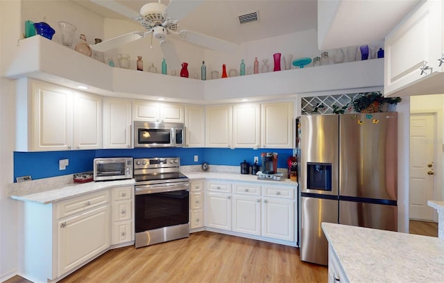 kitchen featuring white cabinets, light wood-type flooring, stainless steel appliances, and ceiling fan