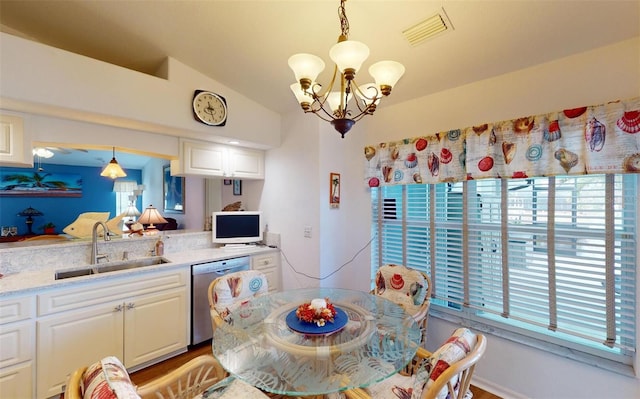 dining space featuring sink, a healthy amount of sunlight, lofted ceiling, and an inviting chandelier