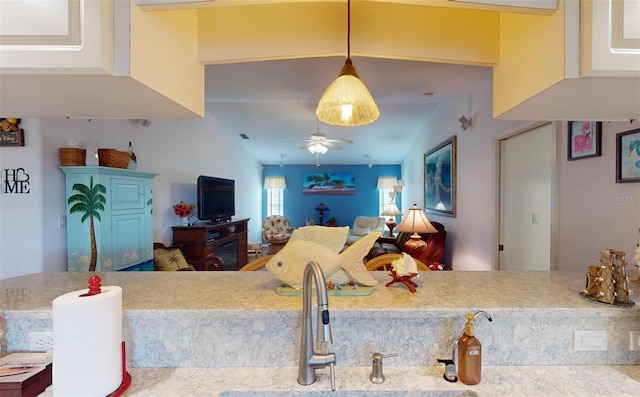 kitchen featuring ceiling fan, lofted ceiling, sink, and decorative light fixtures