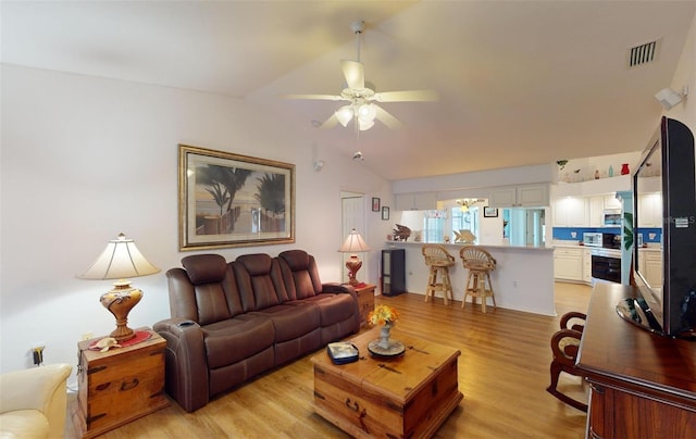 living room with light hardwood / wood-style floors, ceiling fan, and lofted ceiling