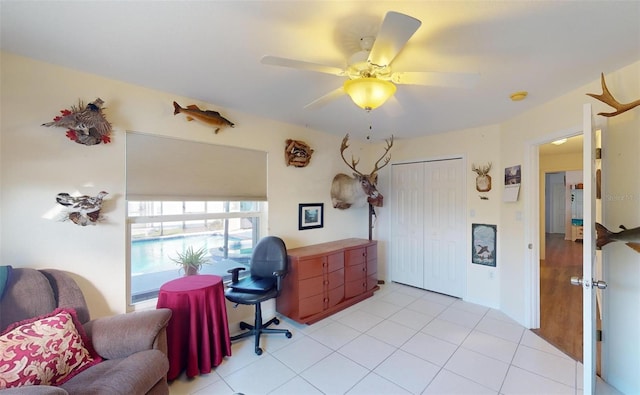 tiled home office featuring ceiling fan