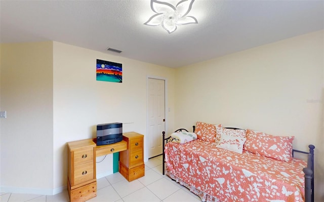 tiled bedroom with a textured ceiling