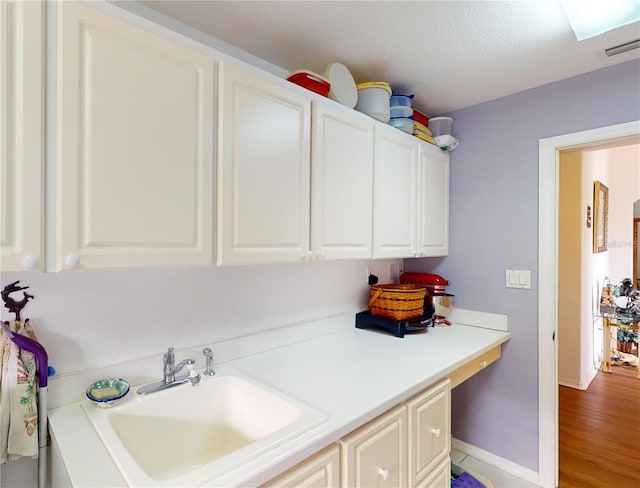 clothes washing area featuring hardwood / wood-style floors, a textured ceiling, and sink