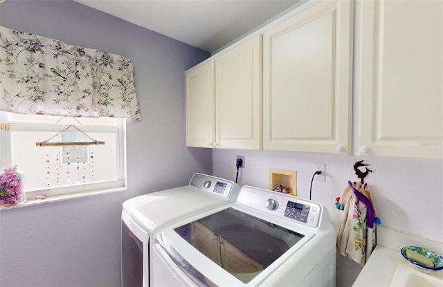 clothes washing area with cabinets and independent washer and dryer