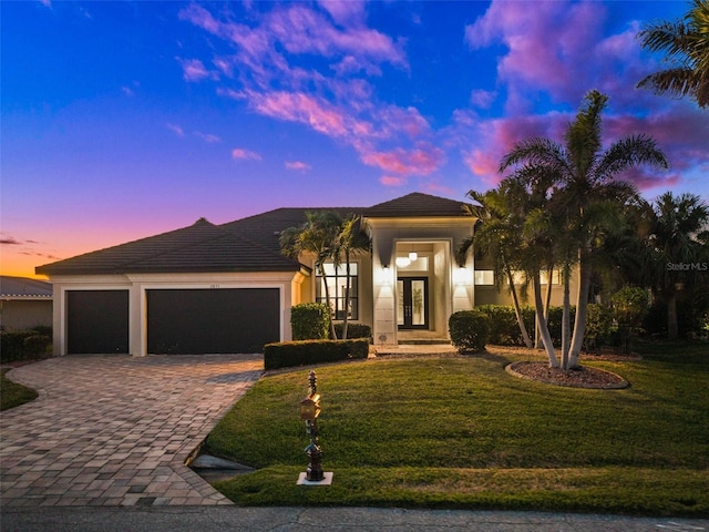 view of front of property with french doors, a yard, and a garage