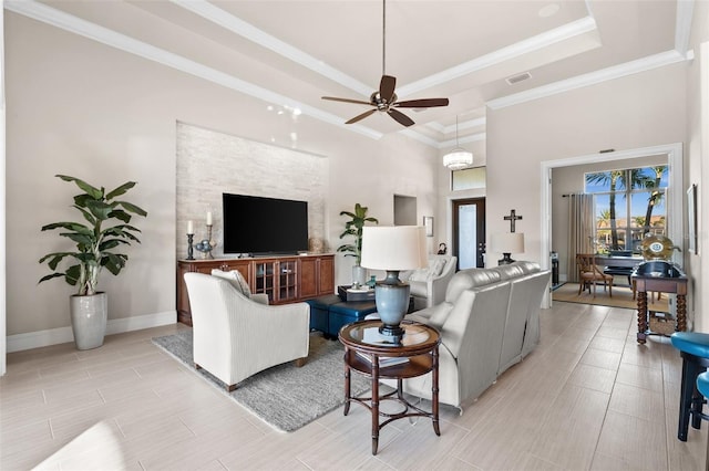 living room with a tray ceiling, ceiling fan, and ornamental molding