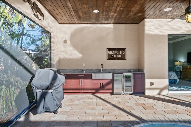 bar featuring wood ceiling, ceiling fan, crown molding, sink, and wine cooler