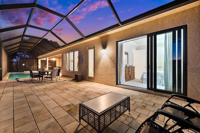 patio terrace at dusk featuring glass enclosure