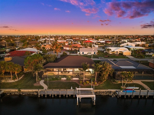 aerial view at dusk featuring a water view