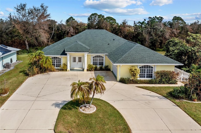 single story home featuring a front yard and cooling unit