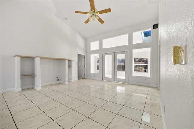 unfurnished living room featuring ceiling fan, light tile patterned floors, high vaulted ceiling, and french doors